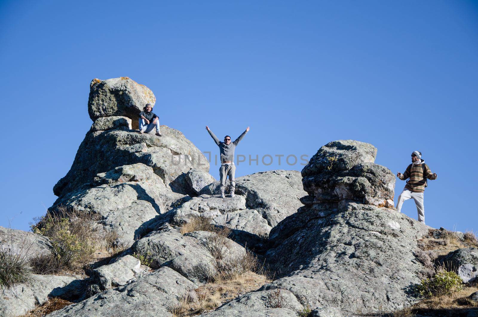 Traveling friends climbing the big rocks in Marcahuasi located east of the city of Lima - Peru