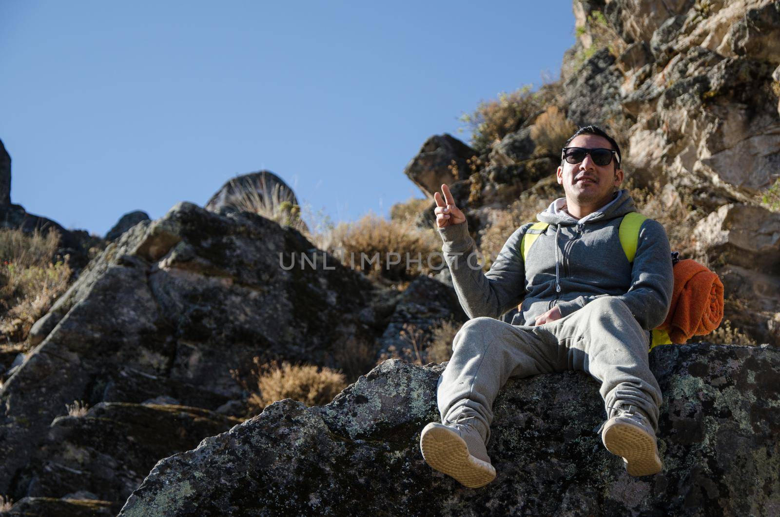 Male traveler sitting on a rock posing for the camera in Marcahuasi located east of the city of Lima - Peru