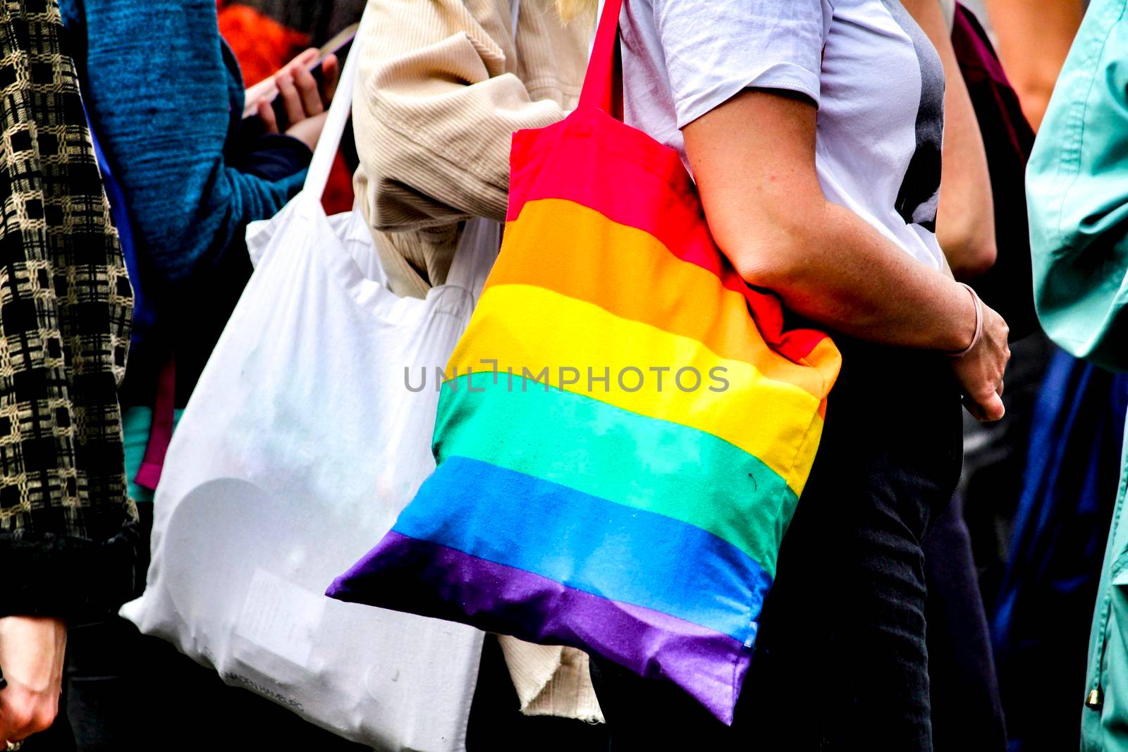 Woman carrying cloth bag in rainbow colors on gay pride day