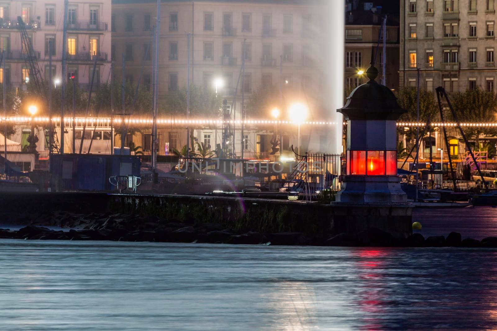 Geneva Lighthouse and water fountain at night. Geneva, Switzerland.