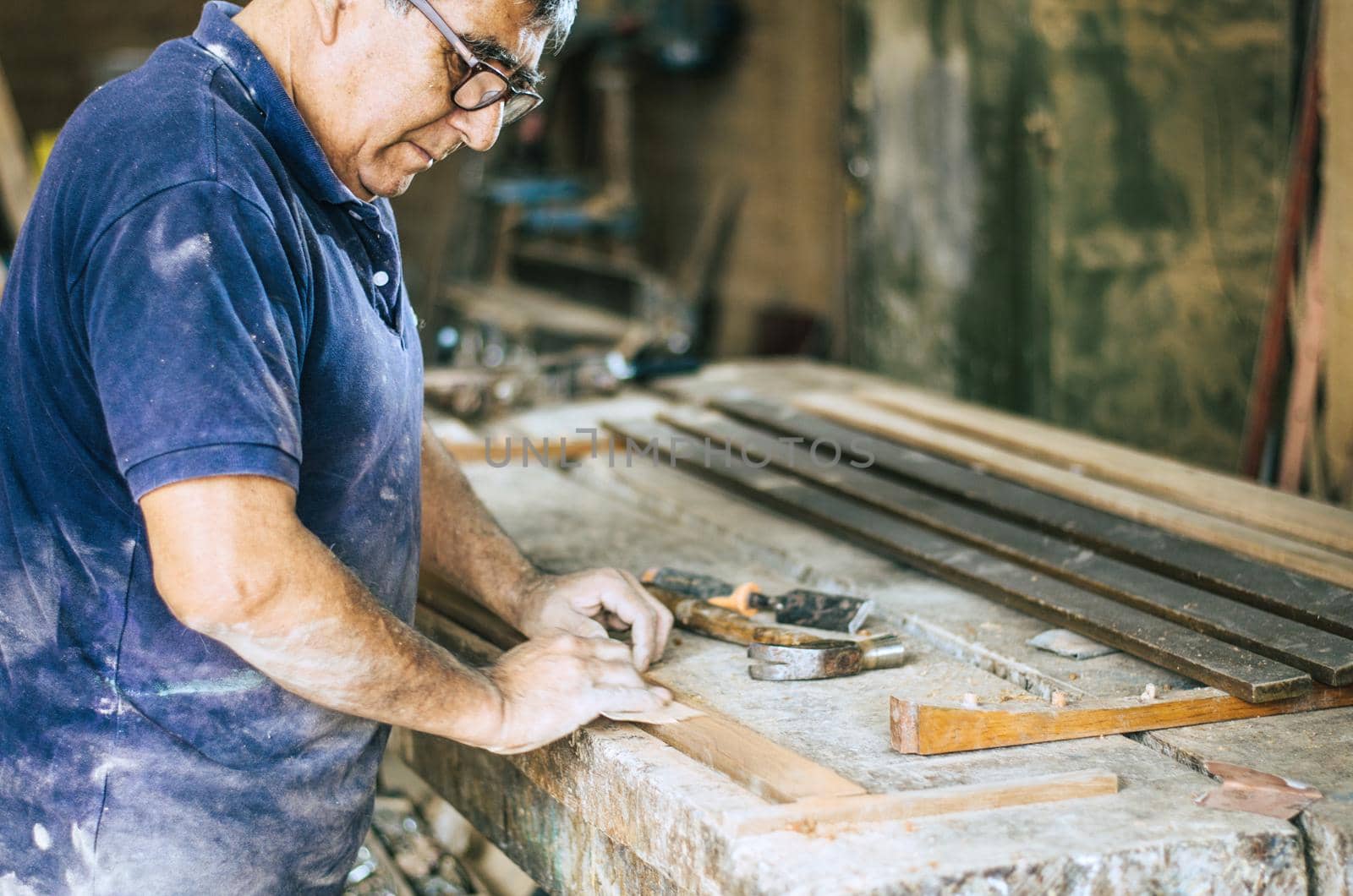 Professional carpenter sanding and restoring wooden surfaces.