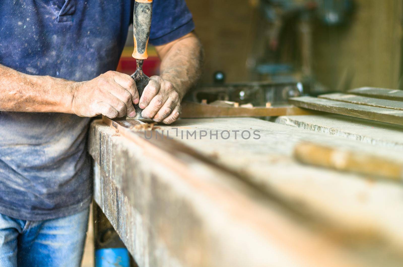 Professional carpenter at work, he is carving wood using a woodworking tool, carpentry and craftsmanship concept