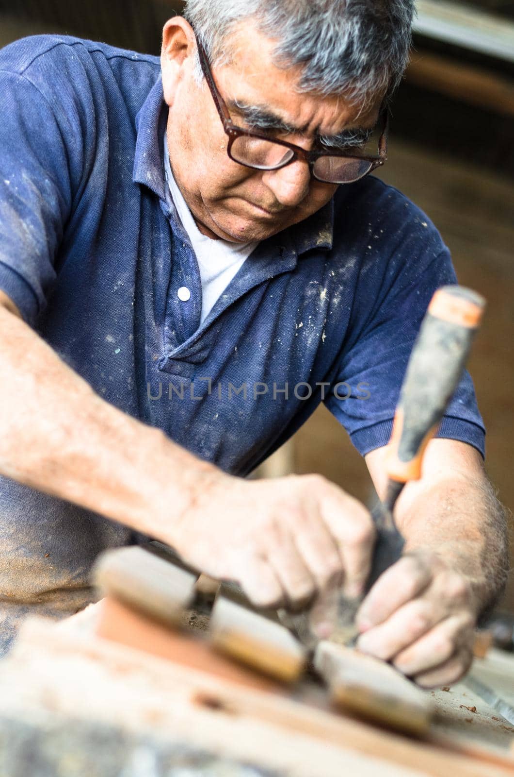 Professional carpenter at work, he is carving wood using a woodworking tool, carpentry and craftsmanship concept