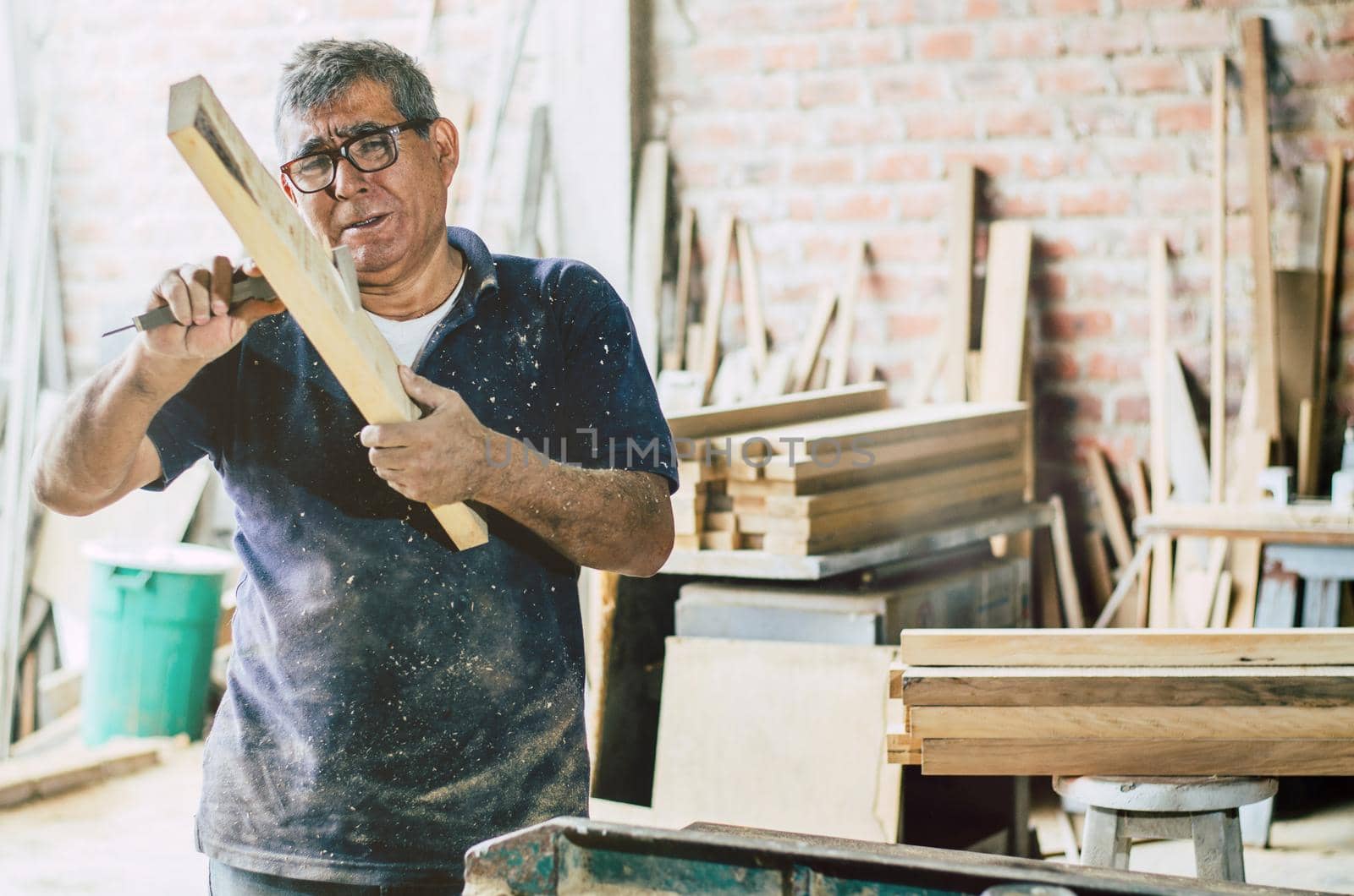 Senior carpenter checking and measures wooden plank. Preparing part for furniture.