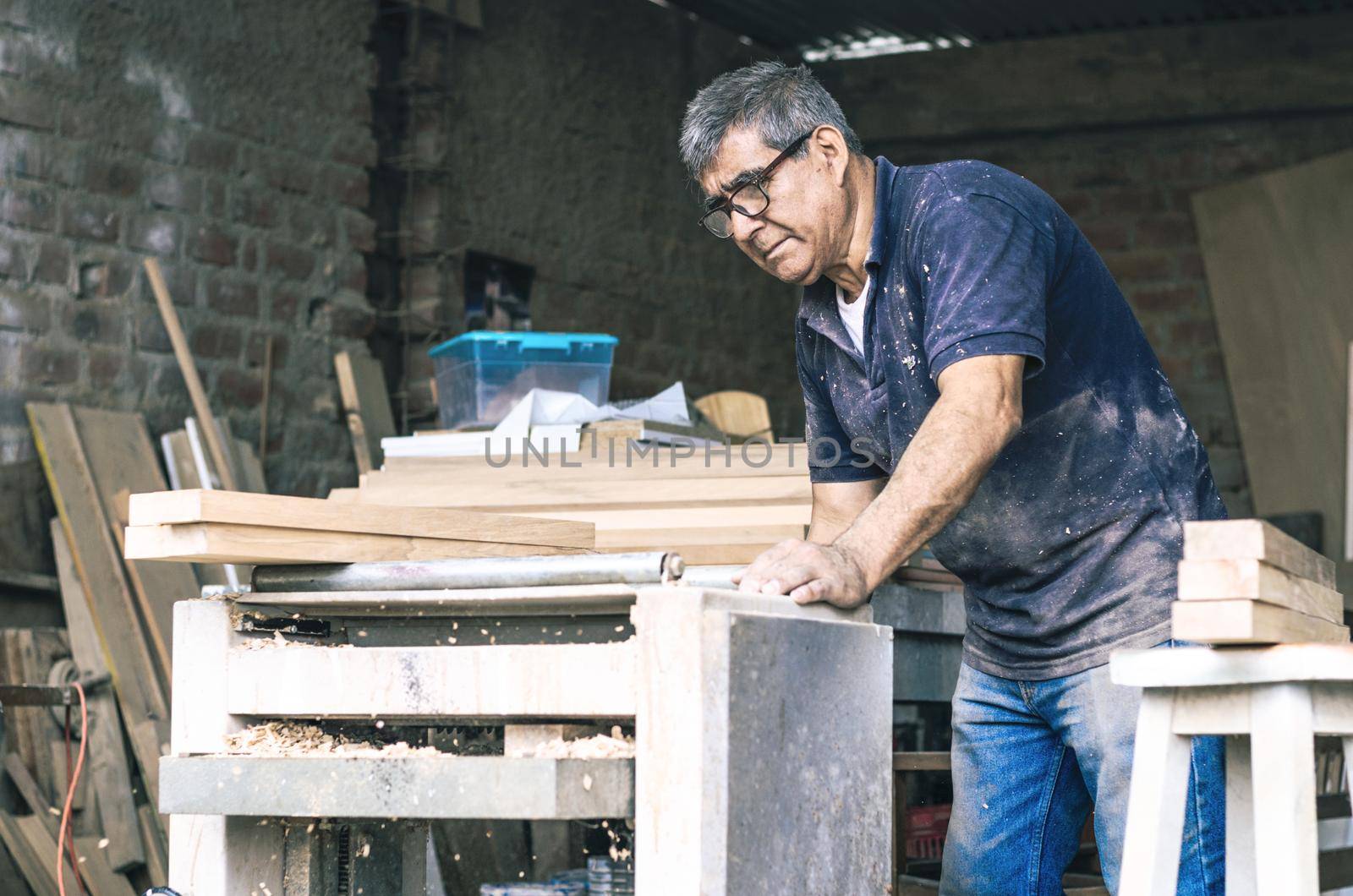 Carpenter using belt sander. Carpenter sanding a wood with belt sander