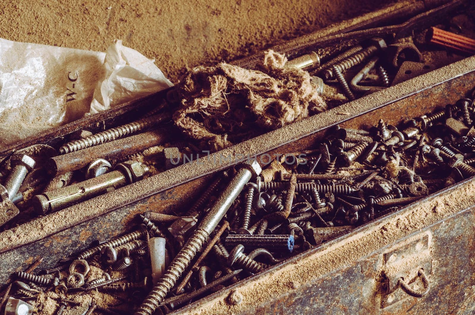 Box full of old screws and nuts in different conditions and sizes.