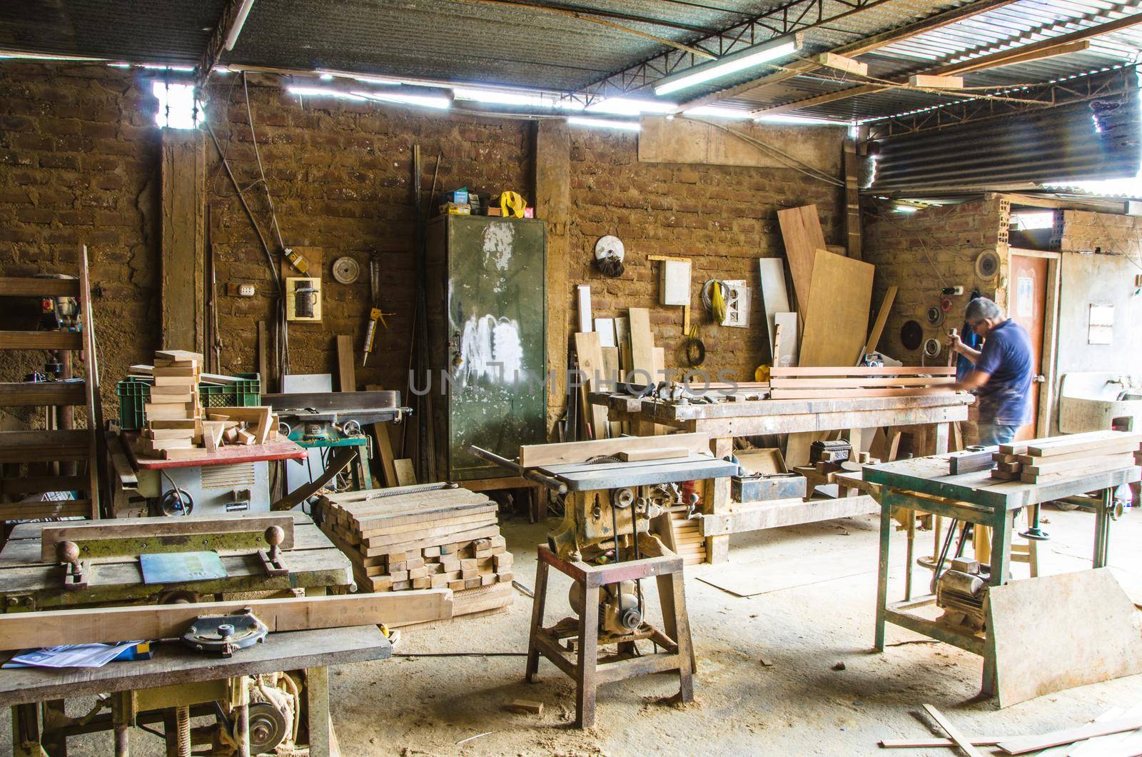 Man doing woodwork in carpentry. Carpentry workshop. Carpenter working on wood plank in workshop.