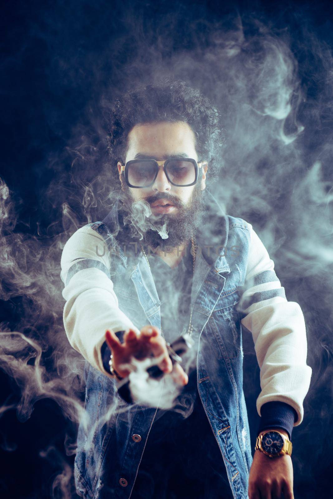 Smoking vape. vaping man holding a mod. Vape Rings. A man launches a ring of smoke. Tricks with smoke.