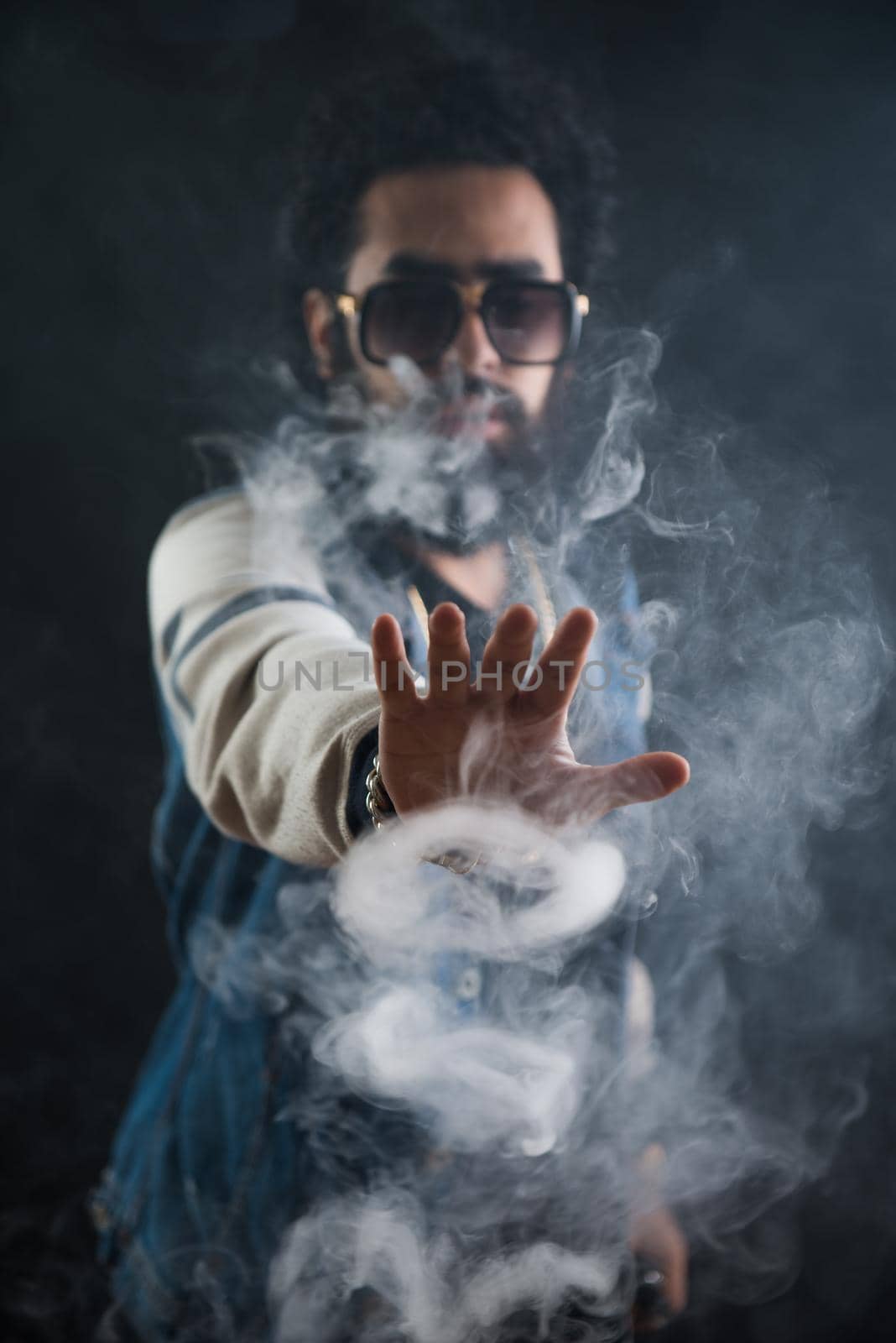 Smoking vape. vaping man holding a mod. Vape Rings. A man launches a ring of smoke. Tricks with smoke.