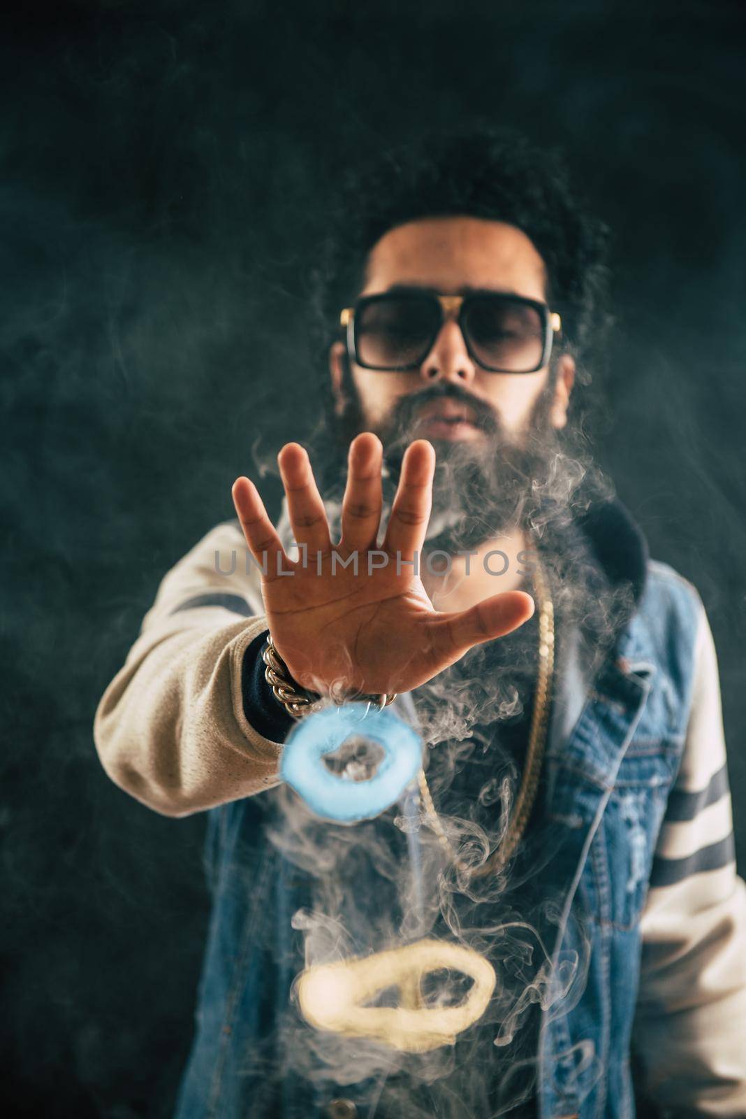 Smoking vape vaping man holding a mod. Vape color rings. A man throws smoke-colored rings. Tricks with smoke.