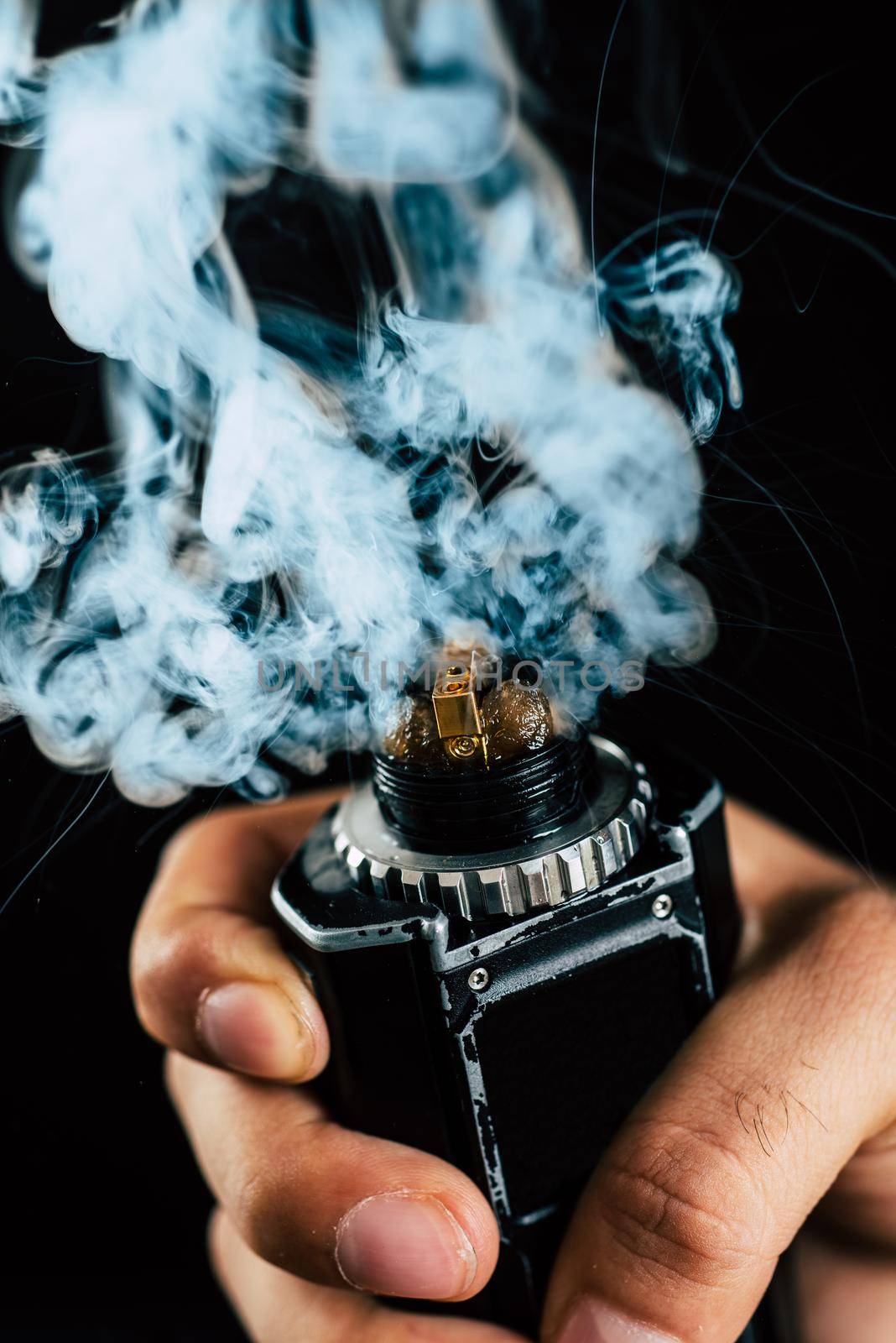 electronic cigarette mechanical mod closeup . a lot of steam . centered on a black background