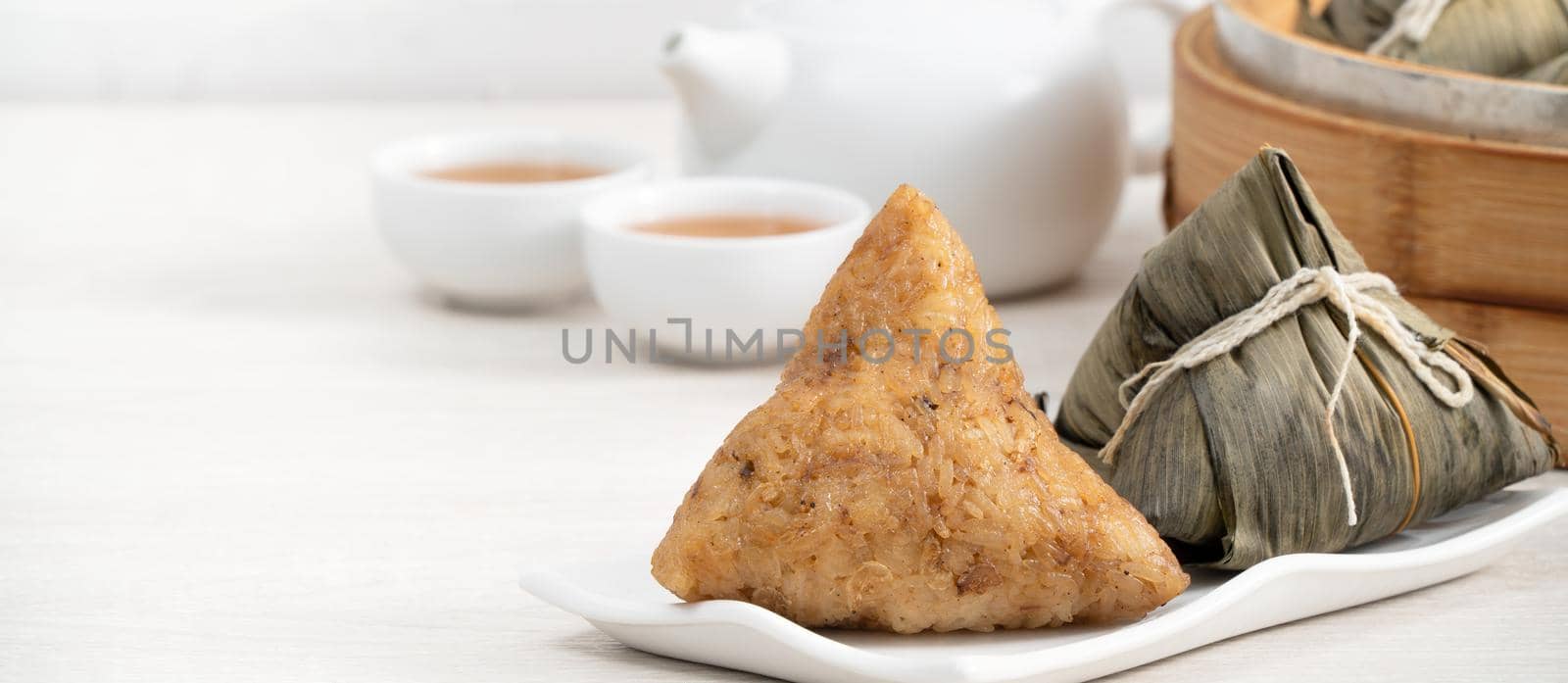 Zongzi. Rice dumpling for Chinese traditional Dragon Boat Festival (Duanwu Festival) on bright wooden table background.