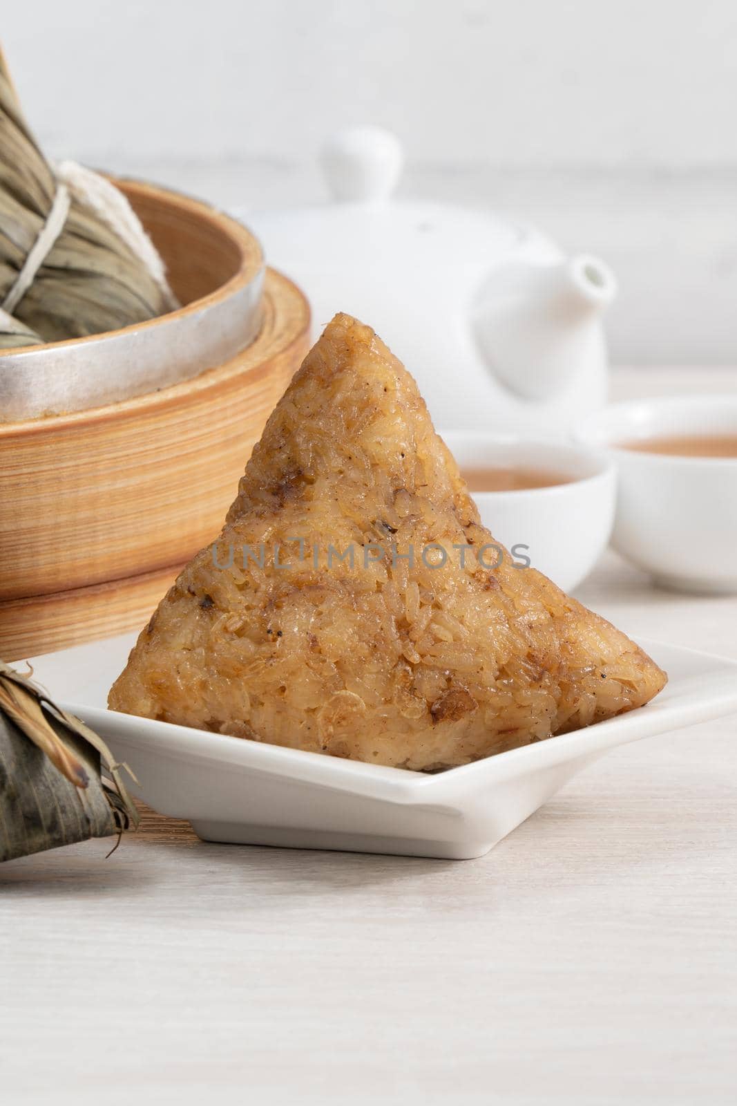 Zongzi. Rice dumpling for Chinese traditional Dragon Boat Festival (Duanwu Festival) on bright wooden table background.