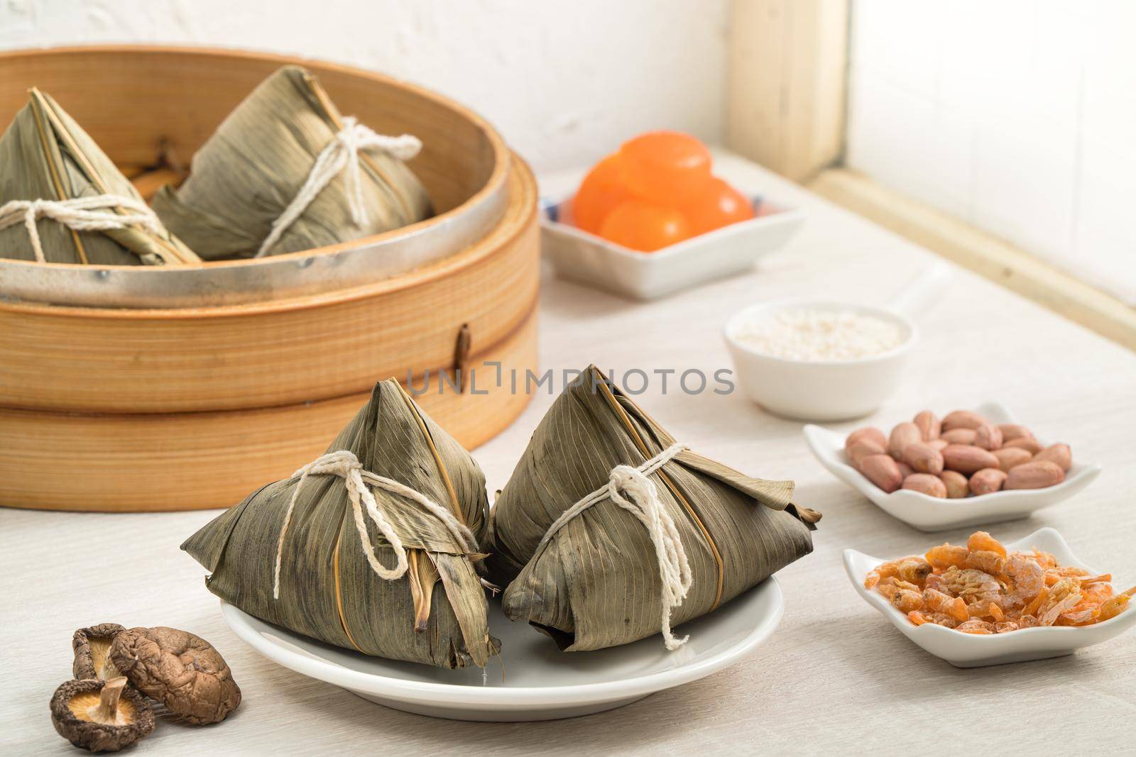 Zongzi. Rice dumpling for Chinese traditional Dragon Boat Festival (Duanwu Festival) on bright wooden table background with window.