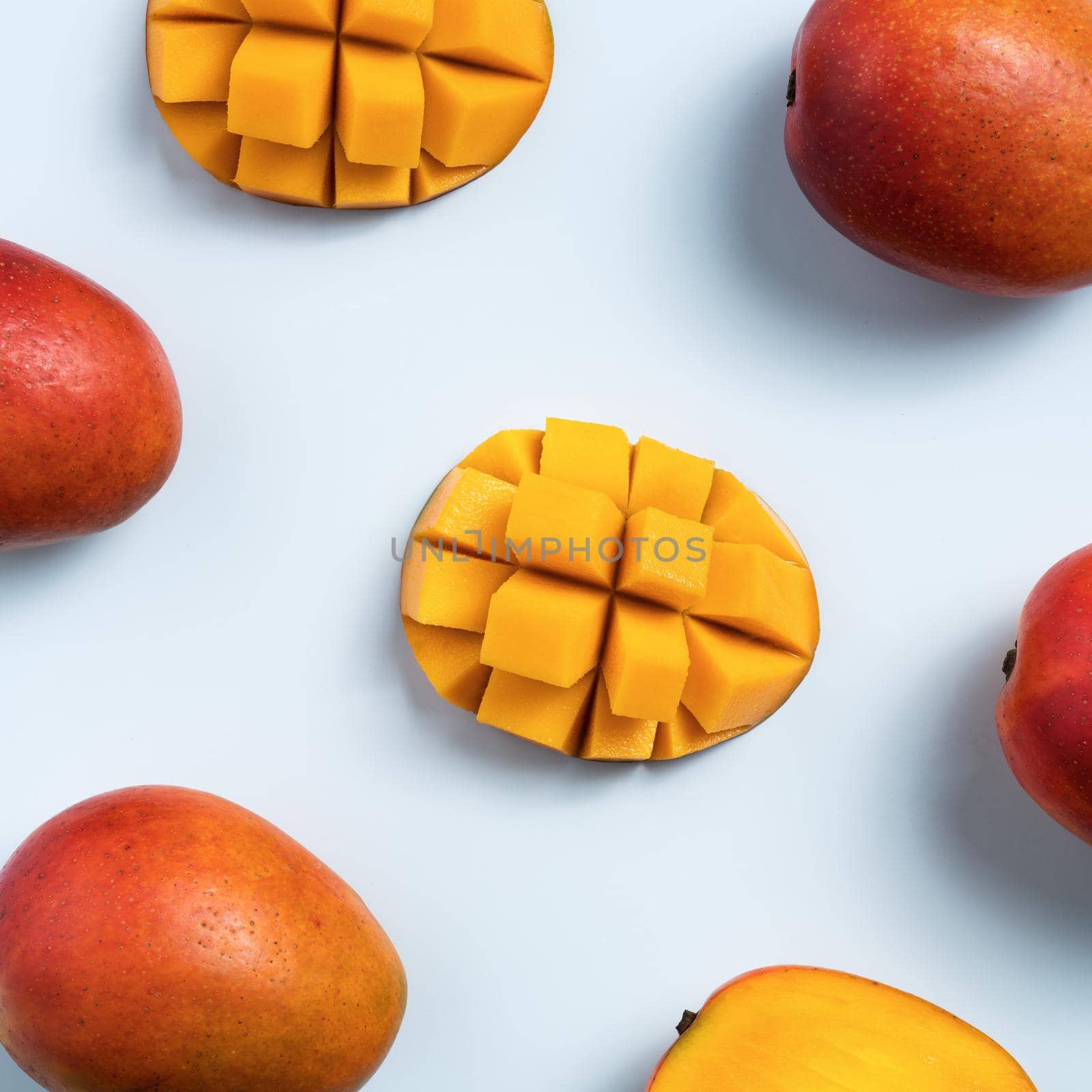 Mango design concept. Top view of diced fresh mango fruit pattern on blue table background.