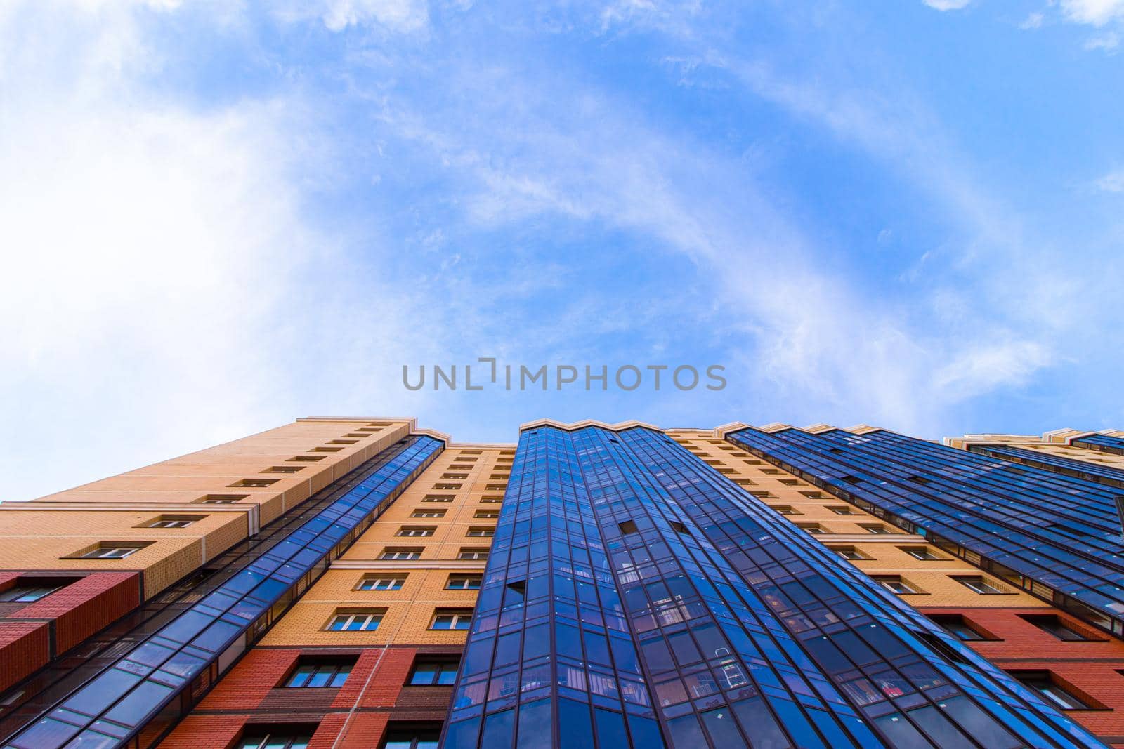 Windows of a high multi-storey residential building. Residential apartment building. Blue sky. Place under the text. Structure. An article about housing. Russia, St. Petersburg April 21, 2020