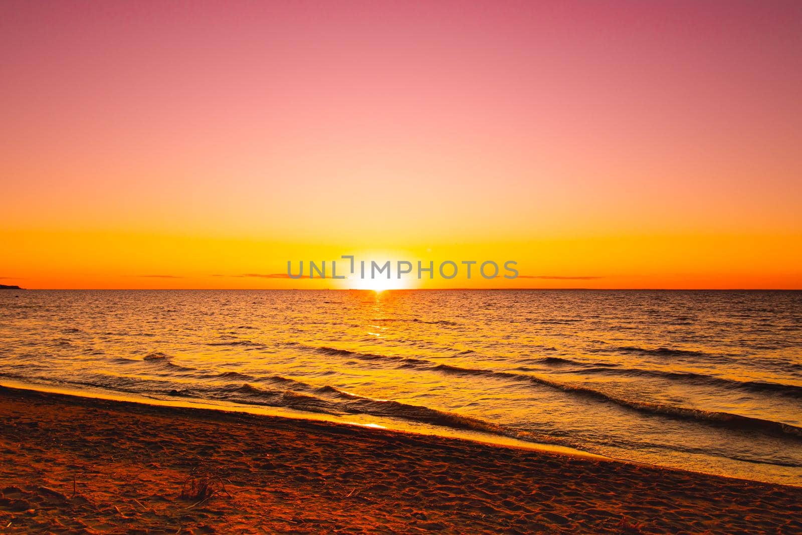 Sunset at sea. Warm sunny sunset over the sea. Sea waves. The sun sets over the horizon. The Gulf of Finland