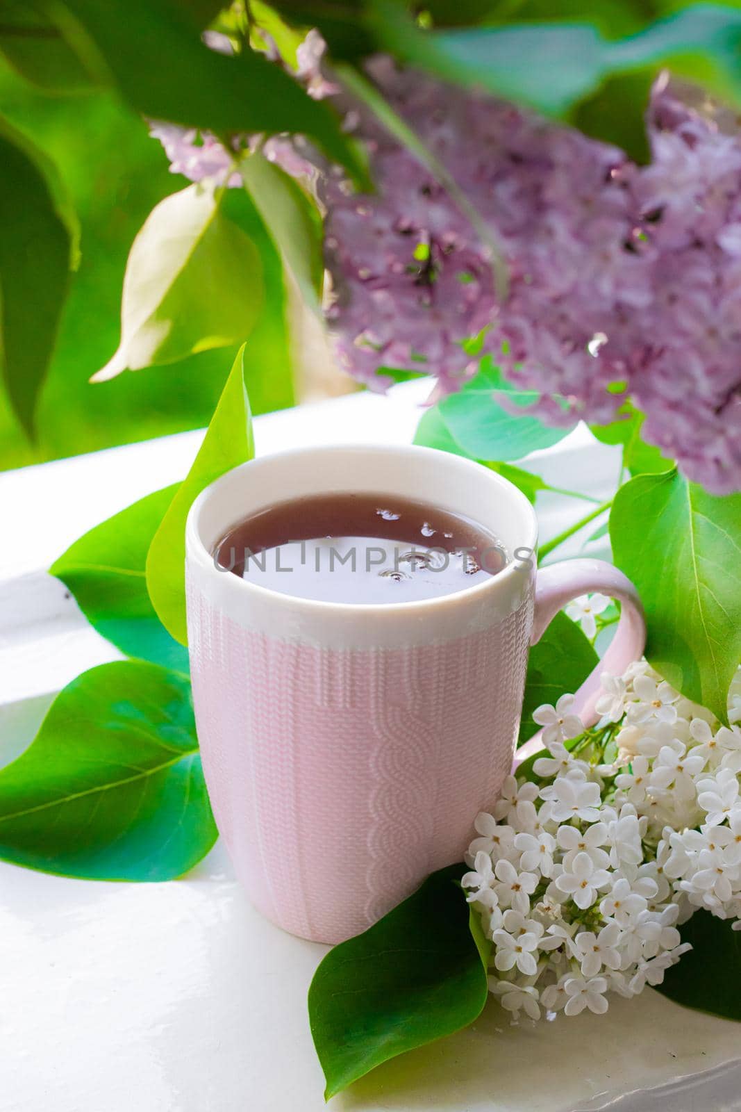 Lilac and tea . Hot drink. Summer flowers. The evening Cup of tea.