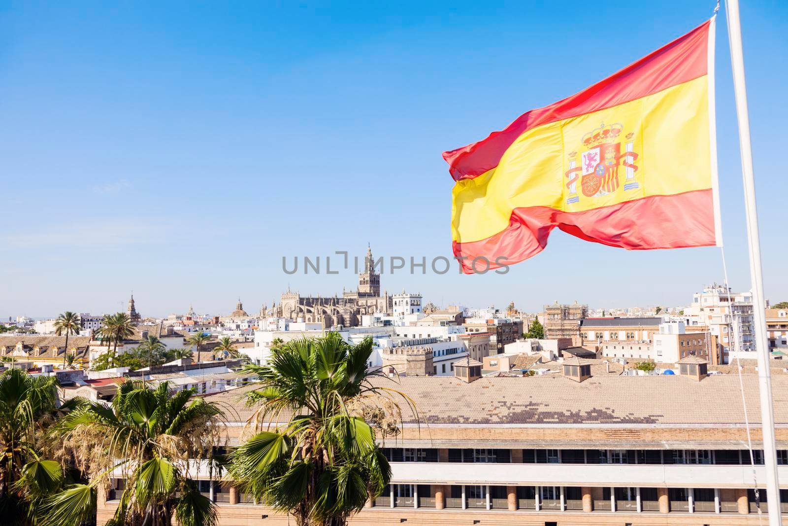 Panorama of Seville with the Cathedral and Spanish flag. Seville, Andalusia, Spain.