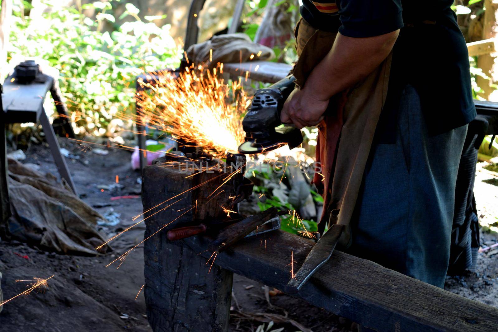 Closeup of a rudimentary iron working process, Cambodia
