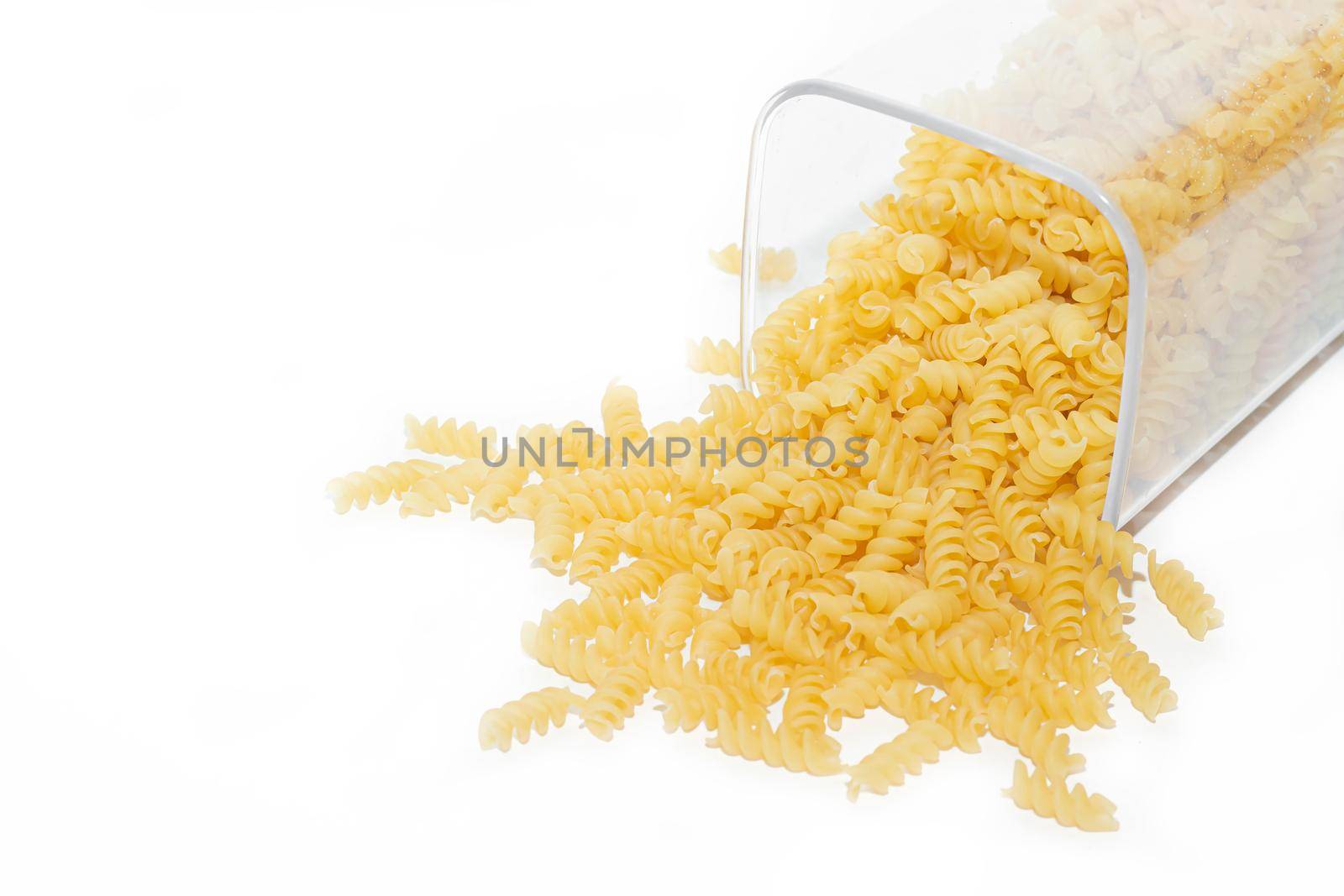 Fusilli macaroni placer . Macaroni spills out of the jar. Article about pasta. Isolated background. Copy space Macaroni. Macaroni banner