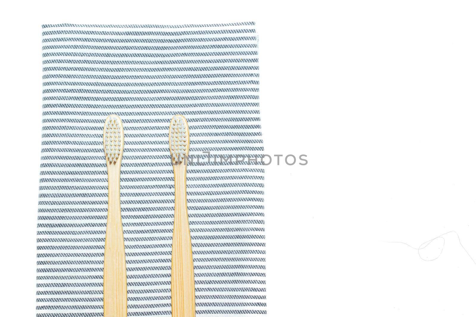 Bamboo toothbrush on a towel. Tooth cleaning. Article about choosing a toothbrush. Article about dental care. Bath accessories. Collection on vacation. Striped towel. Natural material. Eco-products. No plastic surgery. Concern for the environment. Copy space.
