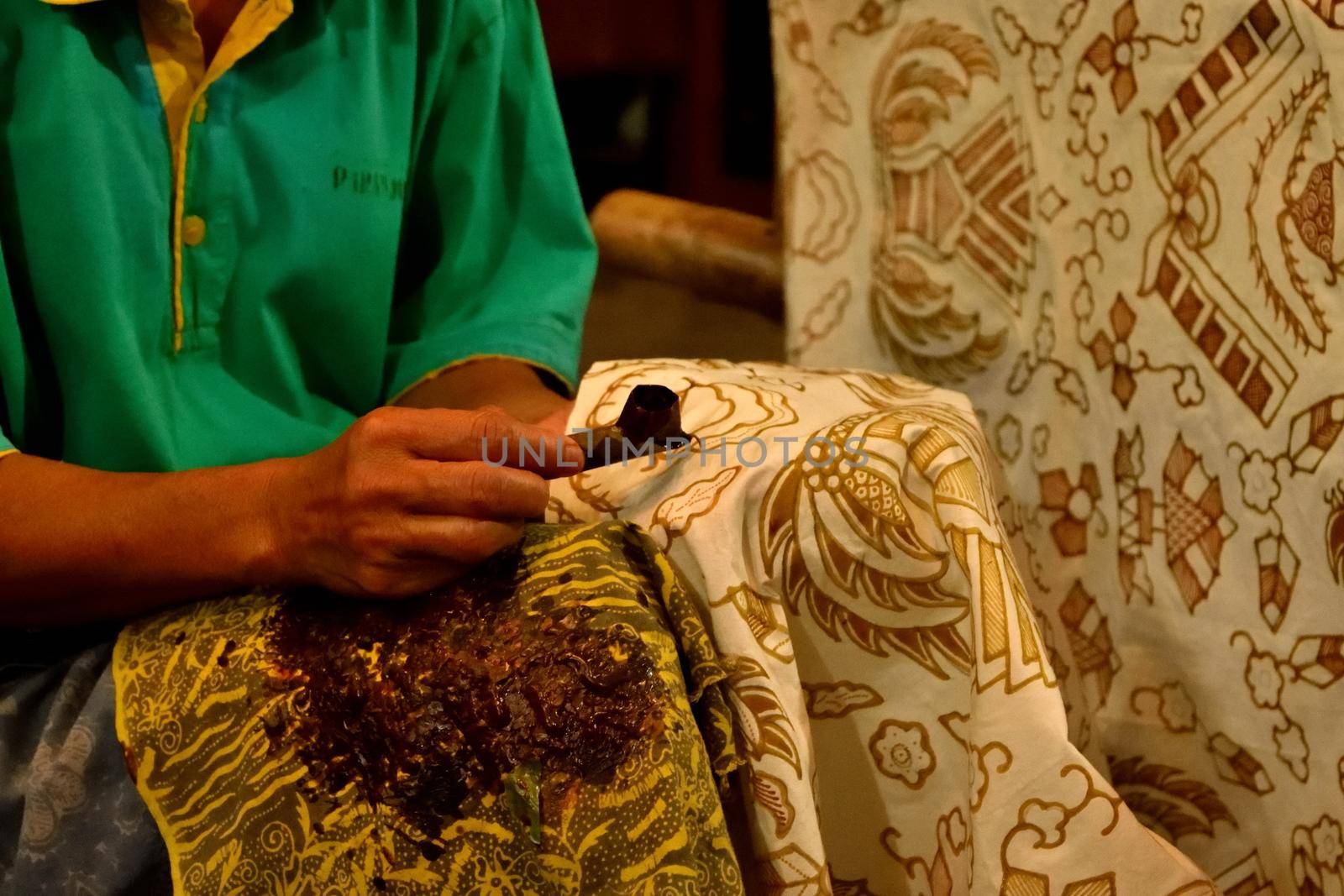 Closeup of a worker who paints Batik fabric, Indonesia