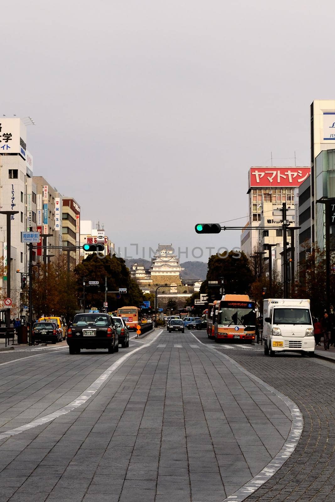 View of Himeji Castle at the bottom of the main street of the city by silentstock639