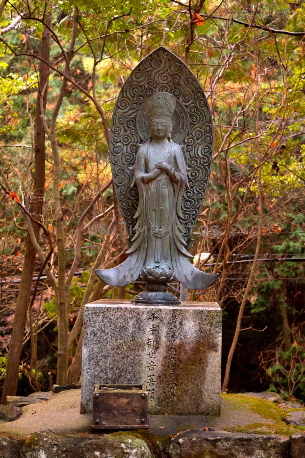 Closeup of a statue in the forest on the mt. Shosha by silentstock639