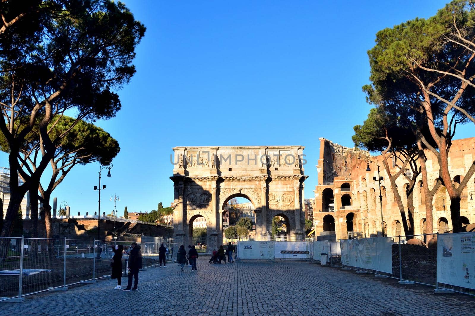 Rome, Italy - December 13th 2020: View of the Arch of Constantine and Coliseum with few tourists due to the Covid19 epidemic by silentstock639