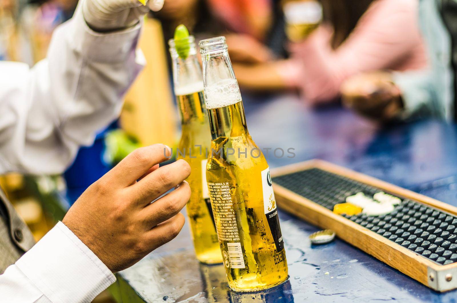 Lima, Peru - October 5th 2018: The waiter uncovers the ice cold beer for the guests at a midday party.