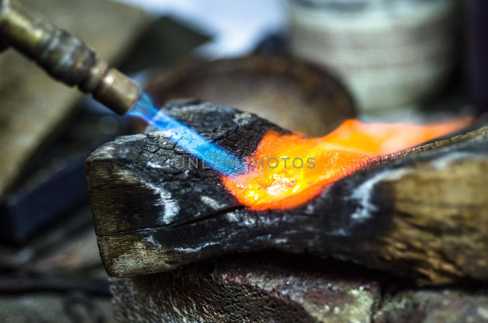 Close-up of jewelry welding with blowtorch. Goldsmith's workshop.