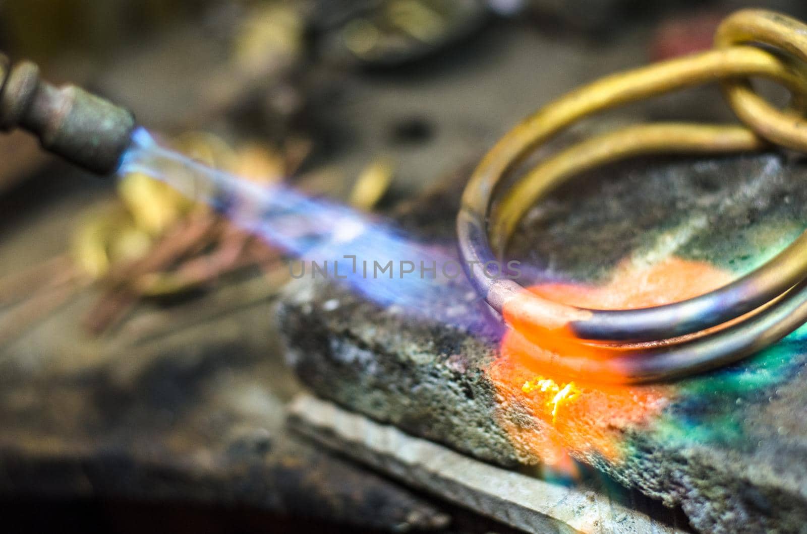 Close-up of jewelry welding with blowtorch. Goldsmith's workshop.