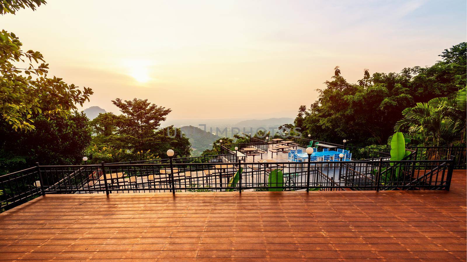 High angle viewpoint for watching the beautiful nature landscape colorful sky during the sunset. Table and chairs on the terrace for dining of the restaurant on the mountain, Chon Buri, Thailand, 16:9