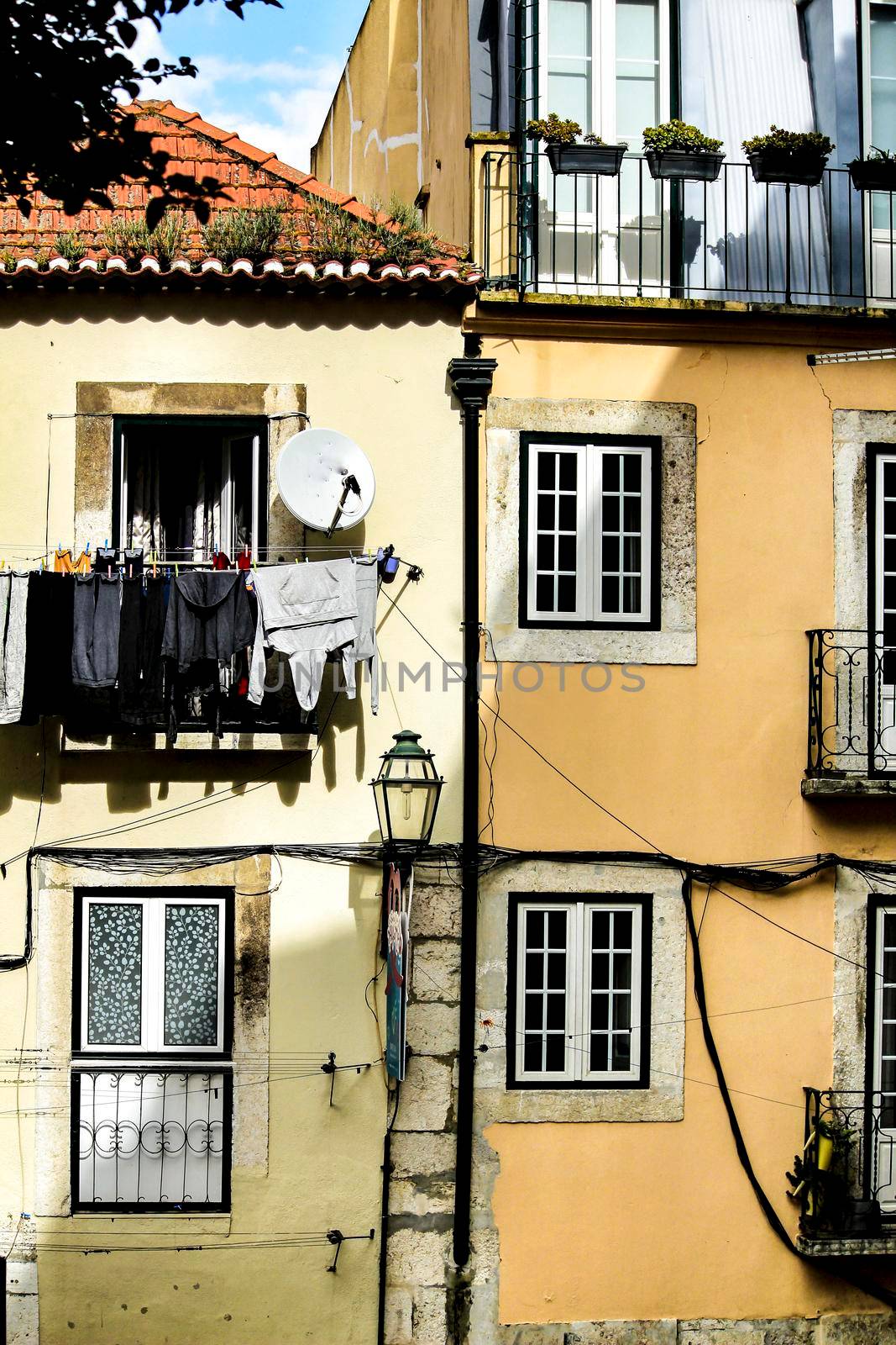 Old colorful and beautiful facades with vintage streetlight in Lisbon streets in Spring.