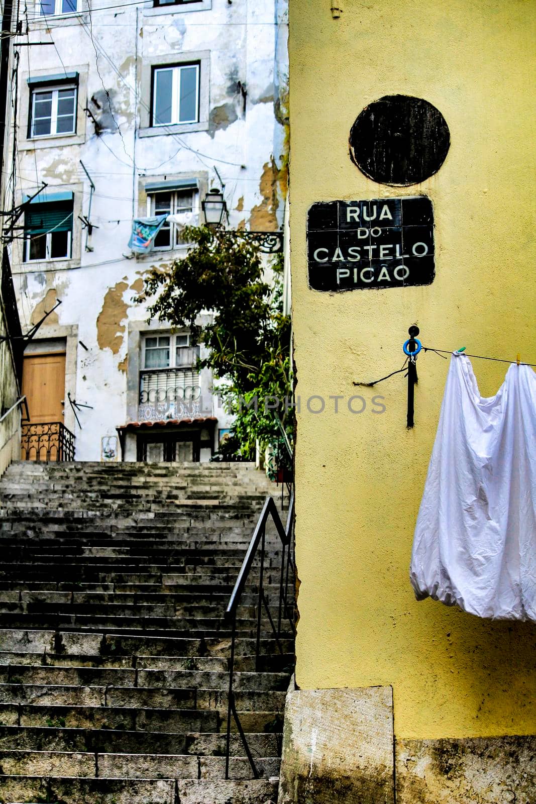 Narrow and colorful streets with majestic facades, windows and balconies of Lisbon city in Portugal in a cloudy day