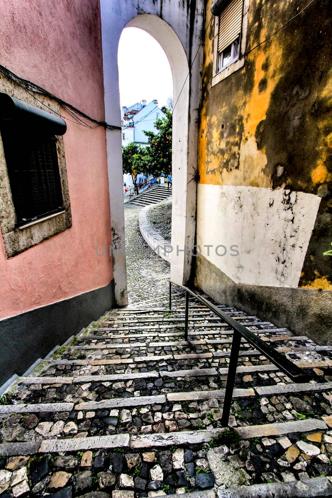 Narrow and colorful streets with majestic facades, windows and balconies of Lisbon city in Portugal in a cloudy day