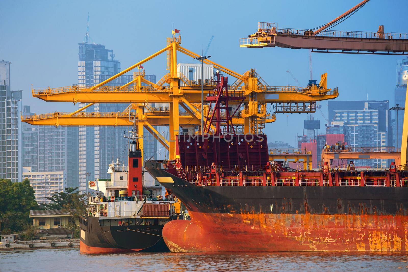 Container ship in export and import business and logistics. Shipping cargo to harbor by crane. Water transport International.