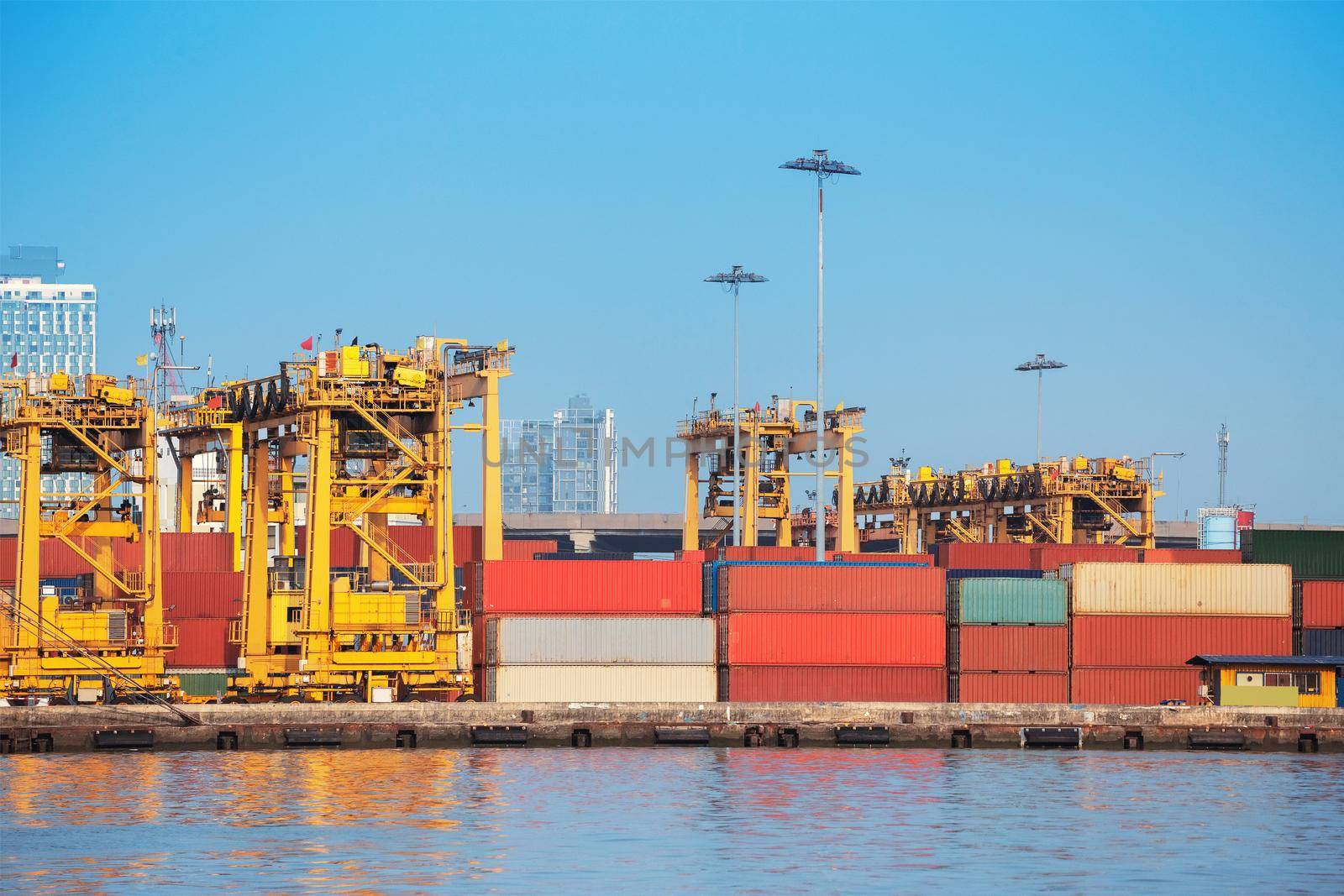 Container ship in export and import business and logistics. Shipping cargo to harbor by crane. Water transport International.