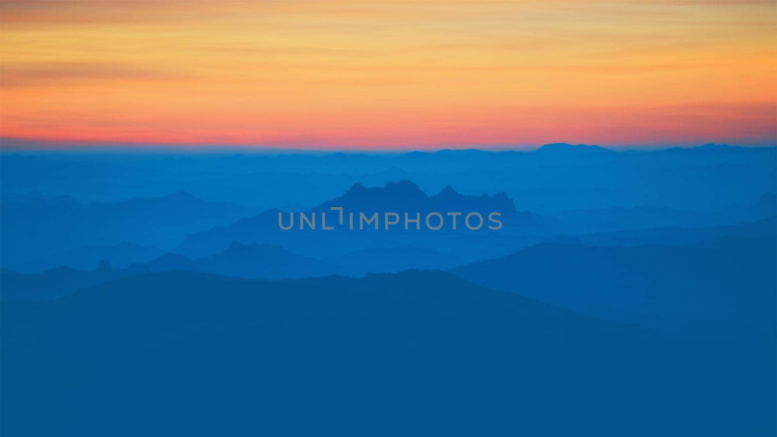 Mountain view in the morning. The background is orange sky.