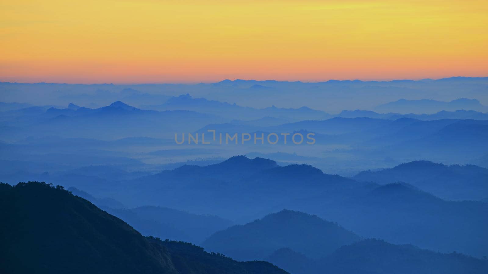 Mountain view in the morning. The background is orange sky.
