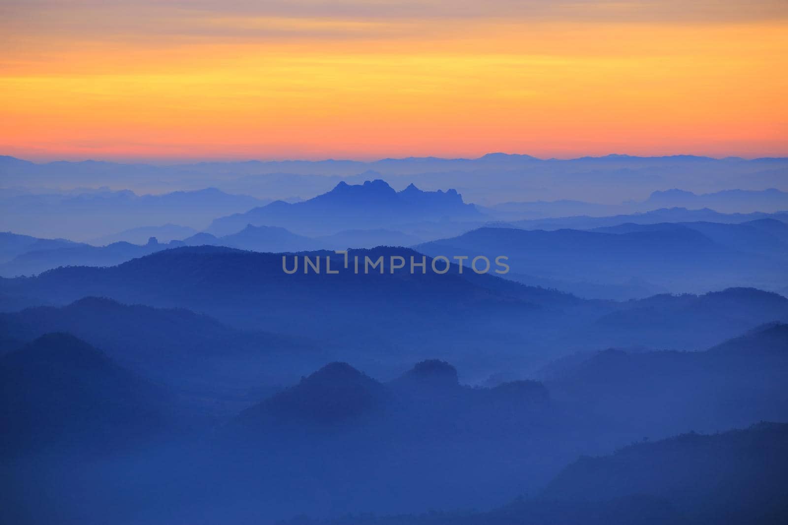 Mountain view in the morning. The background is orange sky.