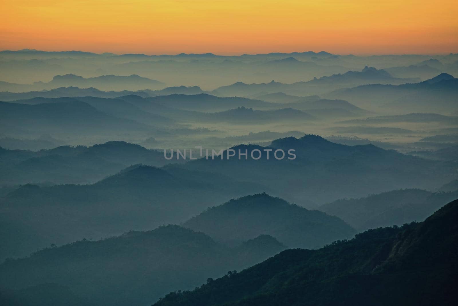 Mountain view in the morning. The background is orange sky.