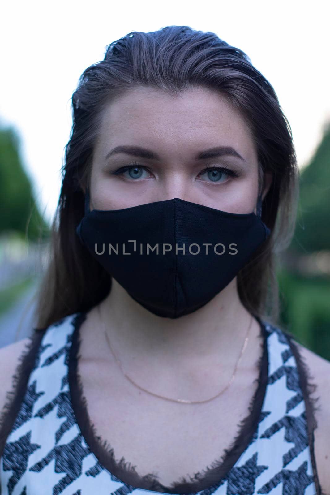 young blonde woman in medical black face mask. Wearing a t-shirt and jeans shorts. modern reality. covid-19 concept by oliavesna