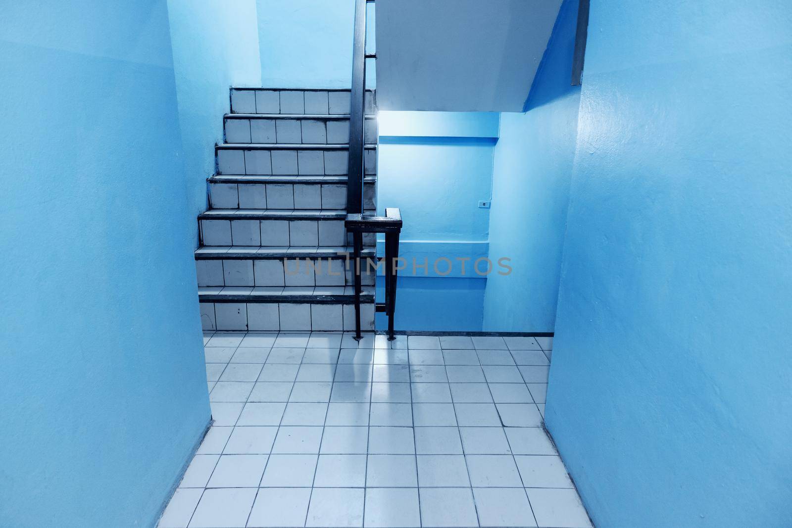 The stairs in the apartment have blue walls