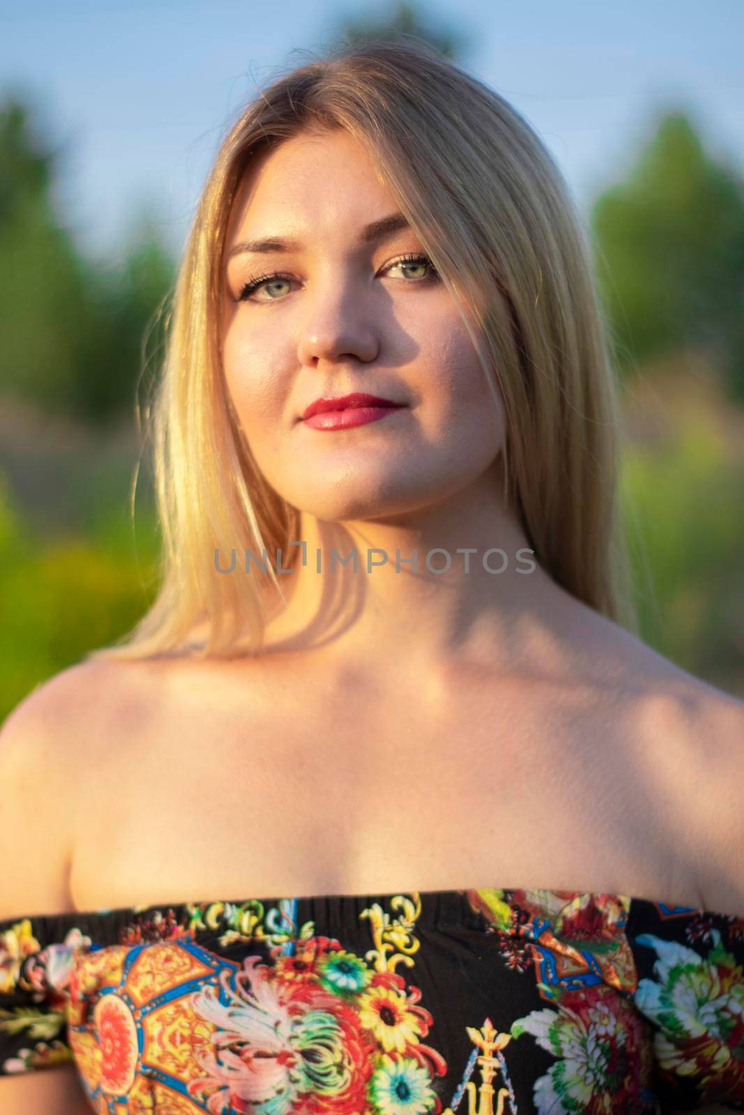 overlight bright portrait of a charming attractive blonde in flowery dress in the field by oliavesna