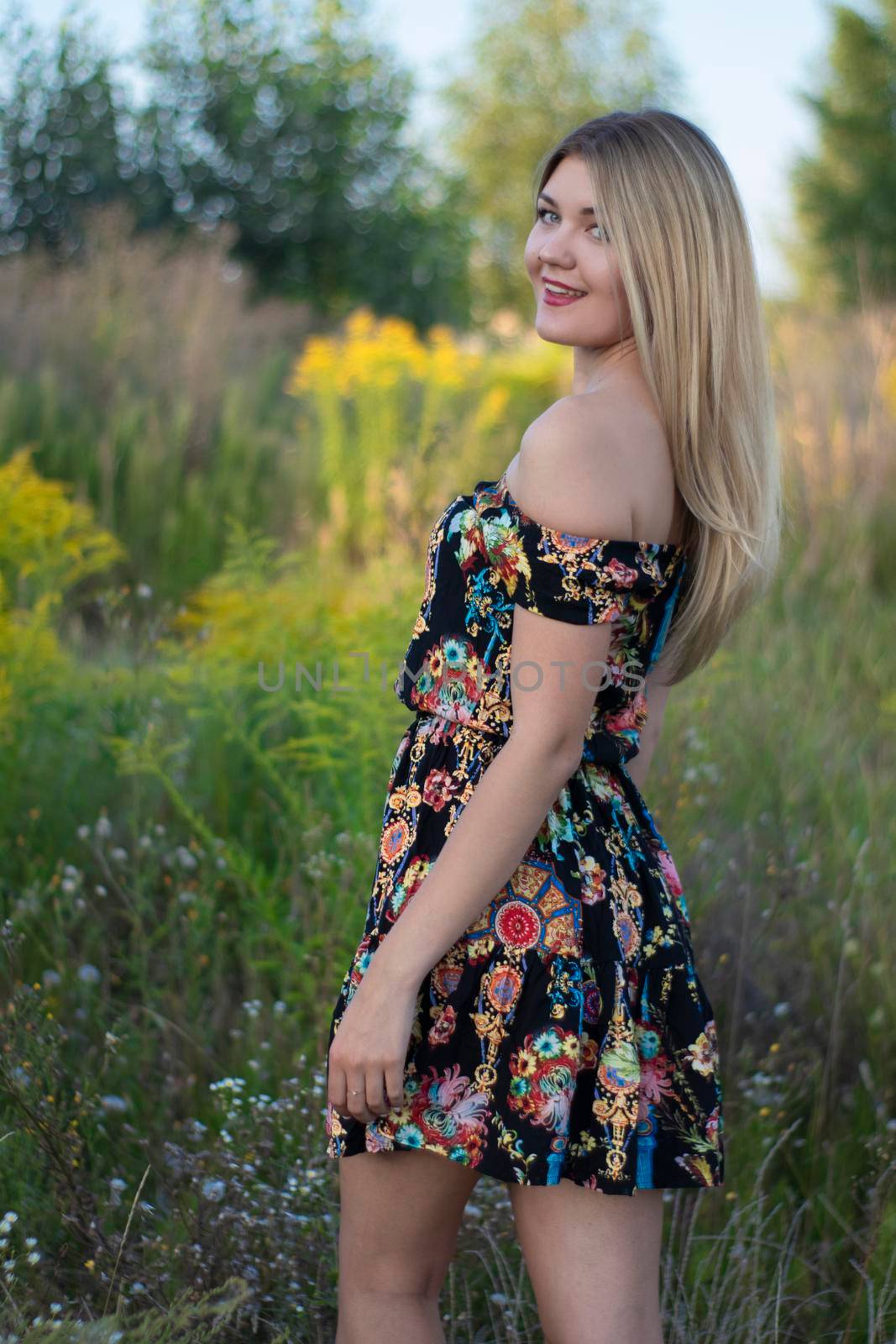 overlight bright portrait of a charming attractive blonde in flowery dress in the field by oliavesna