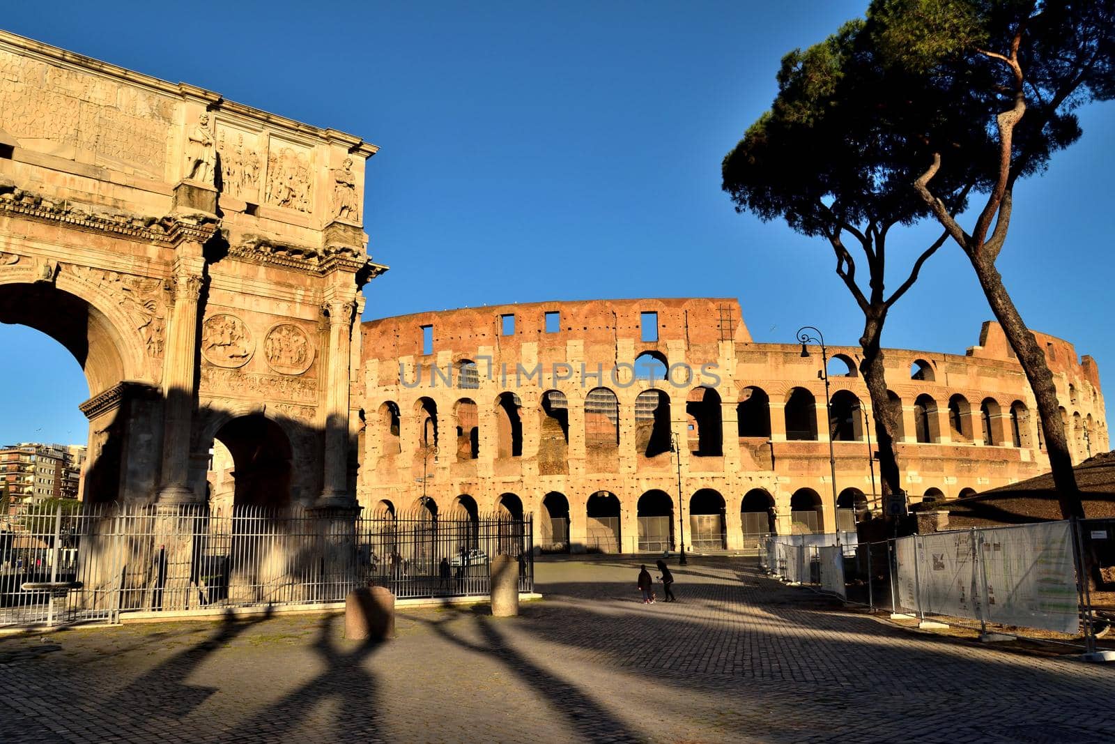 Rome, Italy - December 13th 2020: View of the Arch of Constantine and Coliseum with few tourists due to the Covid19 epidemic by silentstock639