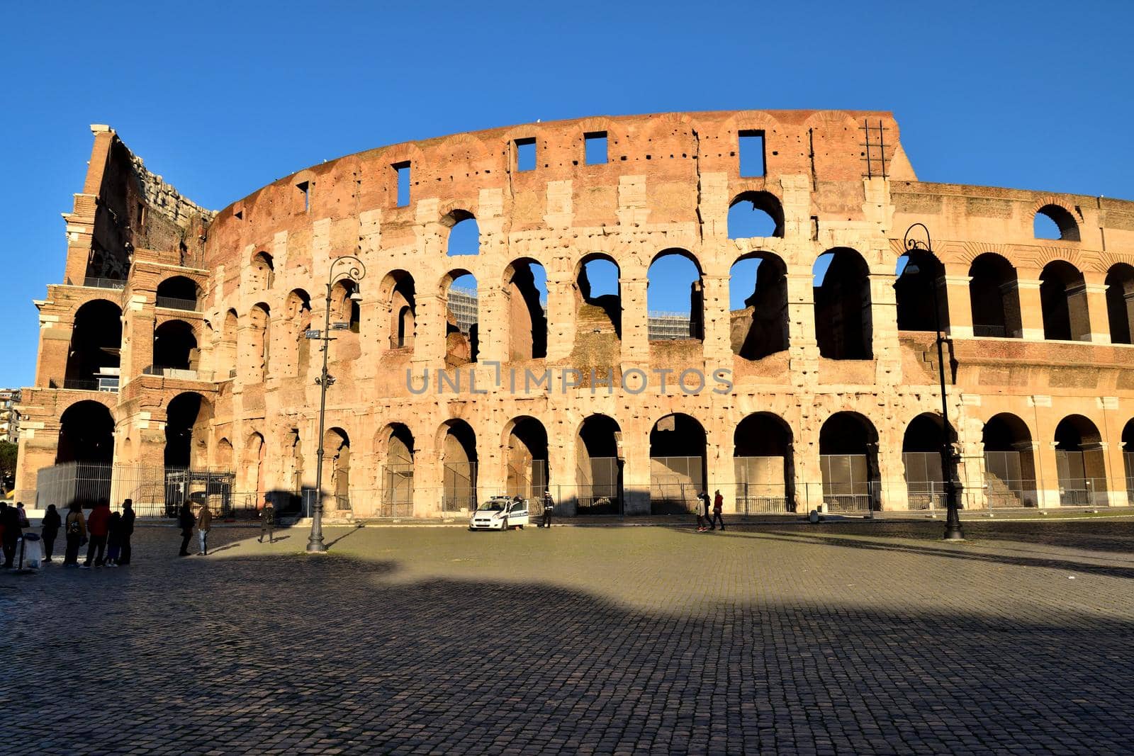 Rome, Italy - December 13th 2020: View of the Coliseum with few tourists due to the Covid19 epidemic by silentstock639