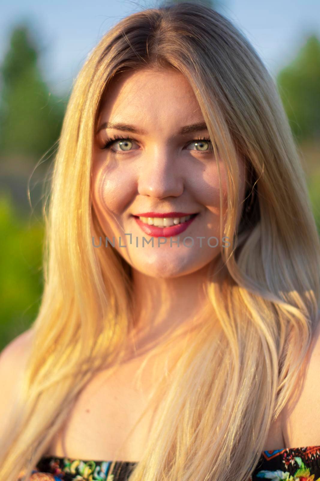 overlight bright portrait of a charming attractive blonde in flowery dress in the field by oliavesna